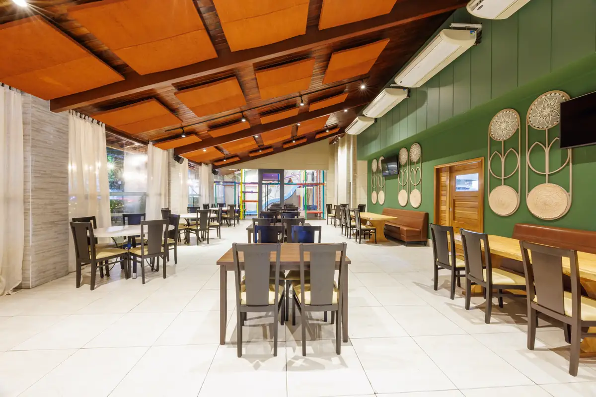 Salão 1, de parede verde, com o brinquedão do espaço kids ao fundo